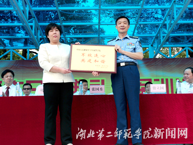 4.空军大校管立国与我校校党委书记张国秀互赠军训奖牌.jpg